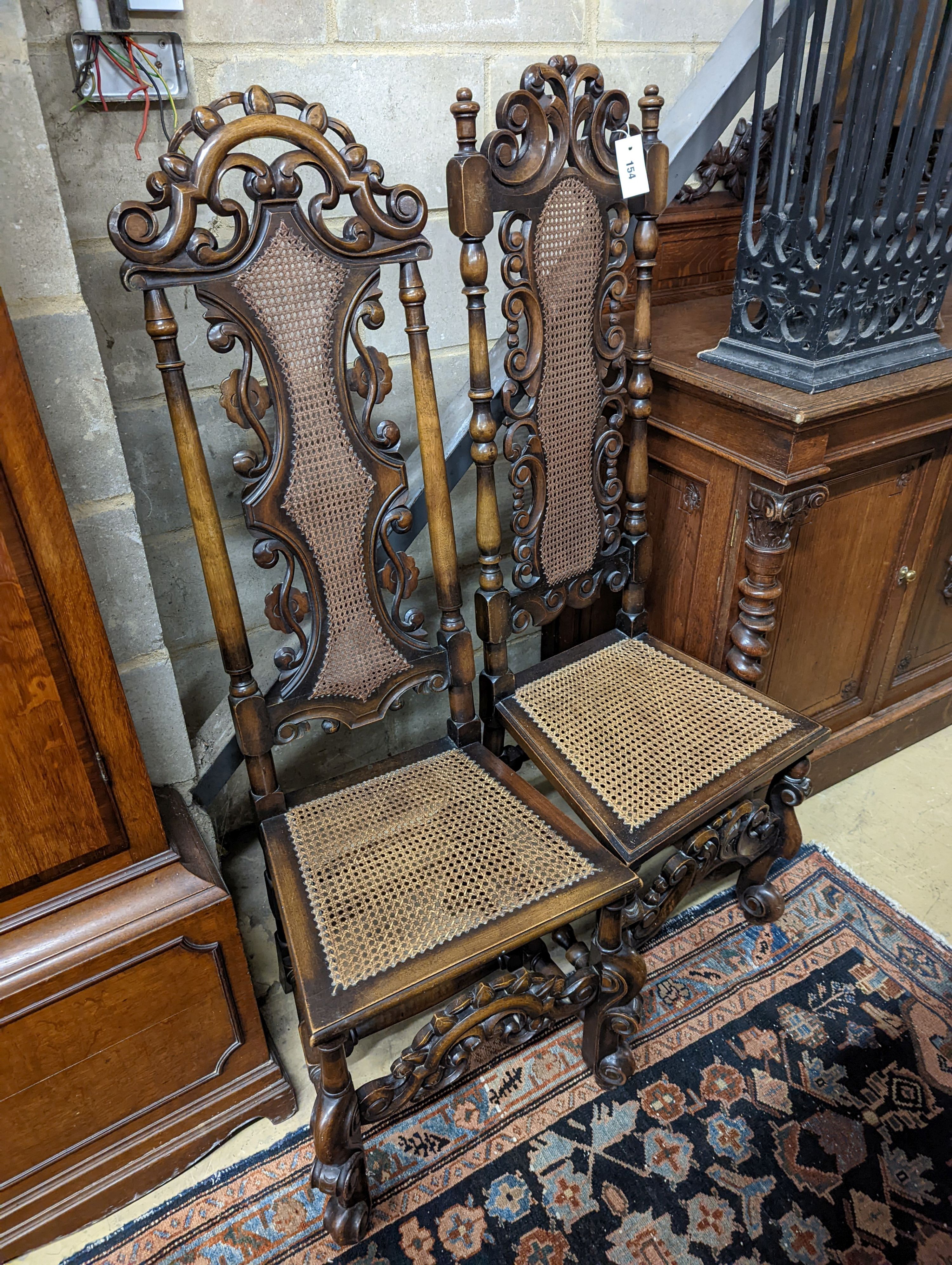 A pair of Carolean design carved beech high back chairs